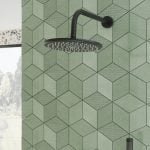matt black shower head and wall arm with a green tiled background